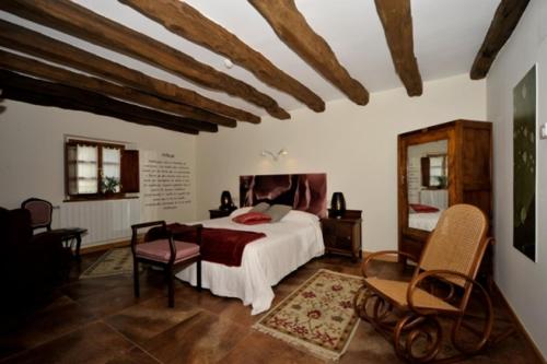 a bedroom with a bed and a table and chairs at Casa Rural Garabilla in Santa Coloma