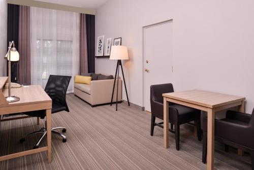 a hotel room with a table and chairs and a couch at Country Inn & Suites by Radisson Raleigh-Durham Airport NC in Morrisville