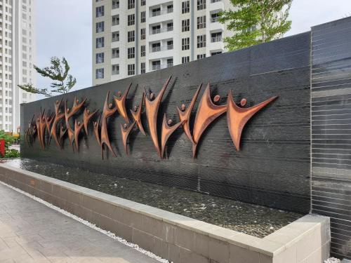 a wall with many pieces of art on it at M-Town Signature Gading Serpong by J`s Luxury Apartment in Pumpangsineng