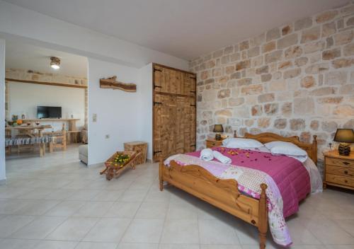 a bedroom with a bed and a stone wall at Villa windmill Near Shipwreck Beach in Volimes