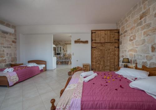 Villa windmill Near Shipwreck Beach by "elite" في Volímai: غرفة نوم بها سريرين وجدار من الطوب