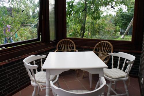 a white table and chairs in a room with windows at Ferienwohnung Harms in Hitzacker