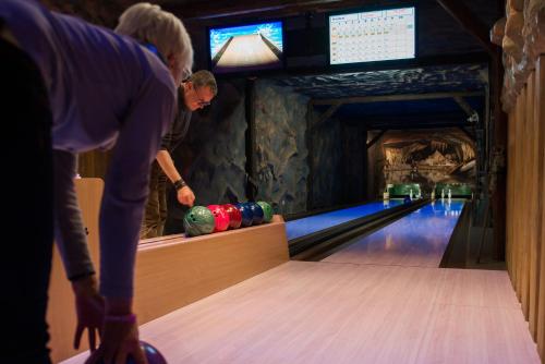 a man playing bowling in a bowling alley at Flair-Waldhotel Mellestollen in Saalfeld