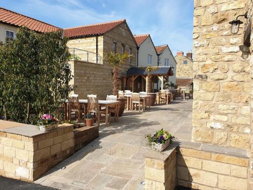 a patio with tables and chairs and a building at The Farrier in Scarborough