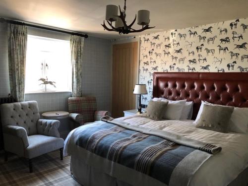 a bedroom with a large bed and a chair at The Farrier in Scarborough