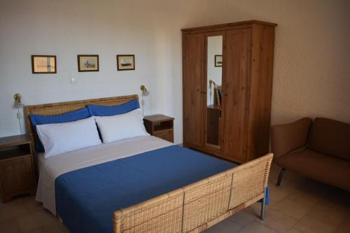 a bedroom with a bed and a couch at Eriketi Studios in Agia Marina Aegina