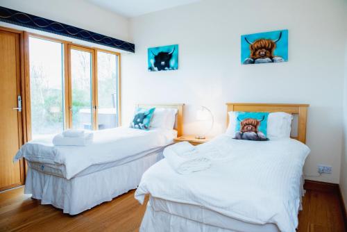 a bedroom with two beds with stuffed animals on them at Clovenstone Lodges in Inverurie