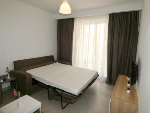 Habitación hospital con cama y sofá en Bugibba 1 Bedroom Apartment, en St Paul's Bay