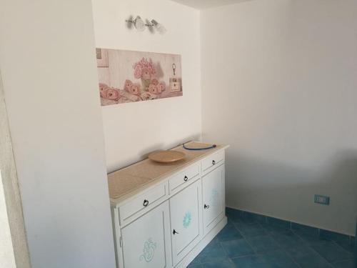 a white cabinet in a room with a picture on the wall at Appartamento centralissimo in San Teodoro in San Teodoro