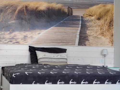 ein Schlafzimmer mit einem Gemälde einer Strandpromenade am Strand in der Unterkunft Strandbude 17 in Heiligenhafen