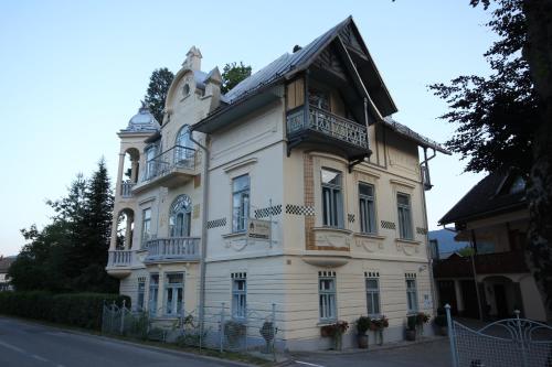 ein großes weißes Gebäude mit Balkon auf einer Straße in der Unterkunft Vila Ana Generoes Bled in Bled
