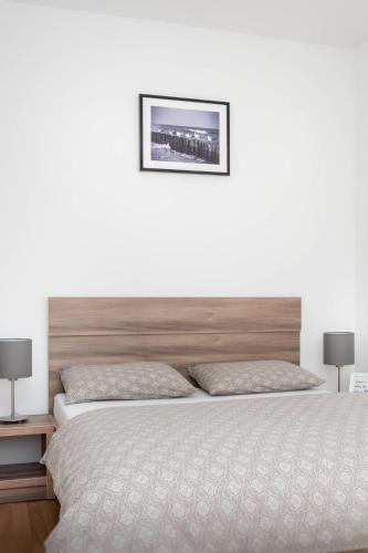 una camera da letto con un letto grande con testiera in legno di Apartment Amber Wind a Palanga