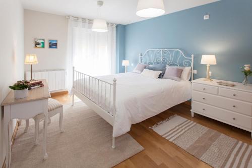 a bedroom with a white bed and a blue wall at Celia in Roa