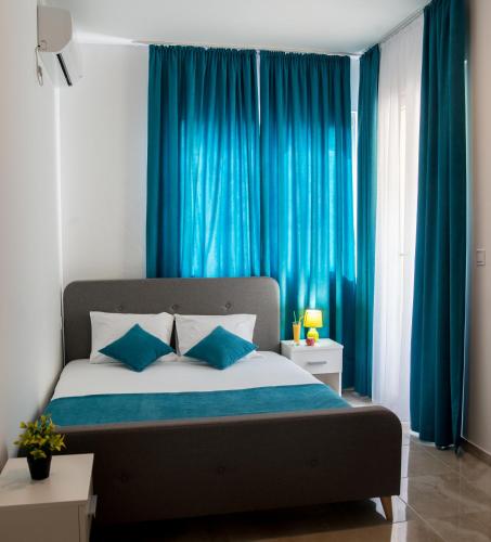 a bedroom with a large bed with blue curtains at Apartments Sunrise in Herceg-Novi