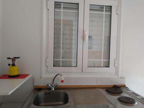 a kitchen with a sink and a window at Valta's Room 2 in Paleros