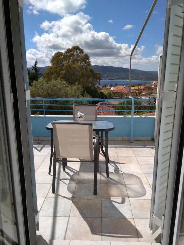 a table and chairs on a balcony with a view at Valta's Room 2 in Paleros