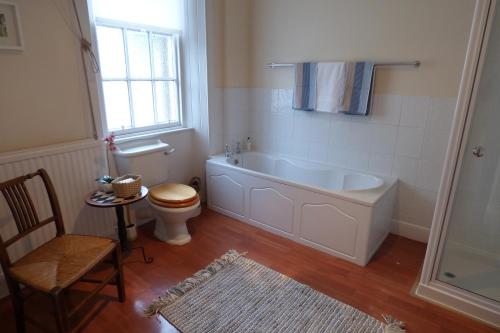 a bathroom with a tub and a toilet and a window at 1 HAVANNAH COURT in Kelso