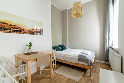 a small bedroom with a bed and a desk at Sopot Spot in Sopot