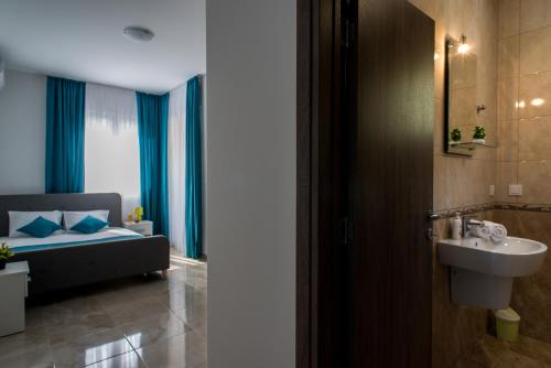 łazienka z łóżkiem i umywalką w pokoju w obiekcie Apartments Sunrise w mieście Herceg Novi