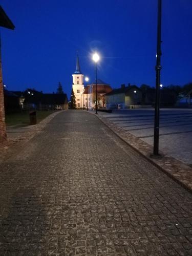 a cobblestone street at night with a white building at Old Town Family Apartment in Valga