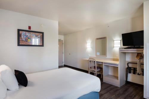 a hotel room with a bed and a desk at Red Lion Inn & Suites Butte in Butte