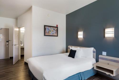 a bedroom with a large white bed with a blue wall at Red Lion Inn & Suites Butte in Butte