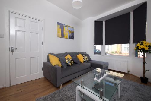 a living room with a couch and a glass table at Stylish and Comfortable Home Away From Home in Liverpool