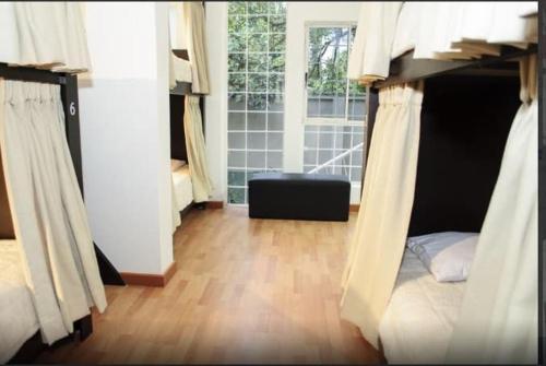 1 dormitorio con litera y suelo de madera en Hostal Lleras Calle 8, en Medellín