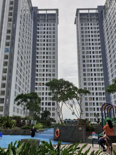 two tall buildings in the background with a pool in the foreground at M-Town Residence Gading Serpong by J`s Luxury Apartment in Tangerang