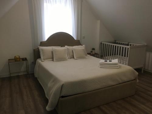 Un dormitorio con una cama con almohadas blancas y una ventana en ALTAMIRA HOUSE, en Viana do Castelo