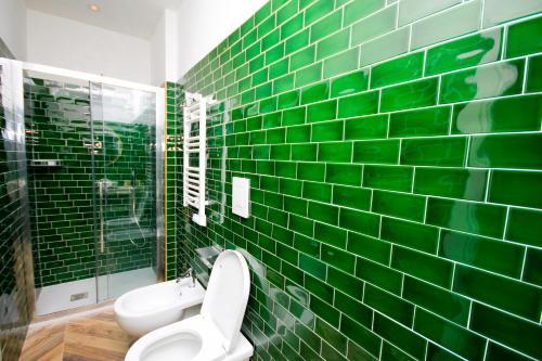een groene betegelde badkamer met een toilet en een douche bij Don Raffaele Resort in Napels