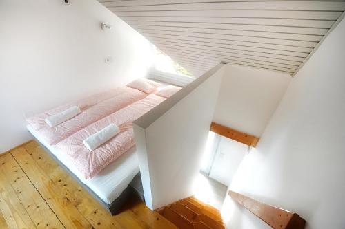 a bedroom with a pink bed in a attic at Villa Oliver 3 Siófok in Siófok