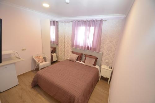a small bedroom with a bed and a window at O Cantinho Guesthouse com Terraço e Vistas em Quinta do Anjo in Quinta do Anjo