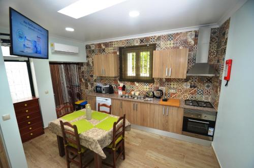 a kitchen with a table and a dining room at O Cantinho Guesthouse com Terraço e Vistas em Quinta do Anjo in Quinta do Anjo
