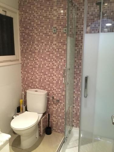 ein Bad mit einem WC und einer Glasdusche in der Unterkunft Flandria appartement 150m from beach in Salou