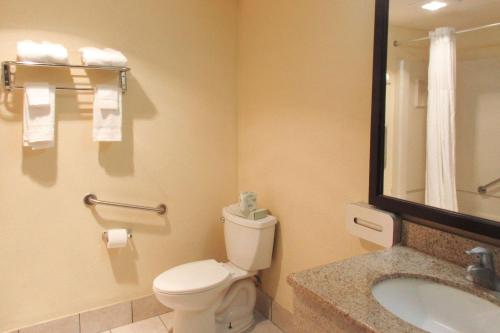 a bathroom with a toilet and a sink and a mirror at Quality Inn & Suites in Cincinnati