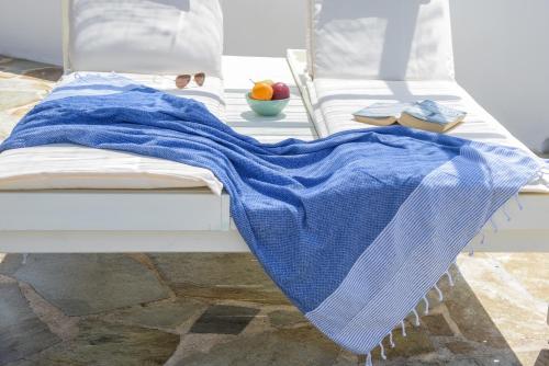 a bed with a blue blanket on it at The Veranda of Gavrion-Exclusive, Centrally located with Seaview in Gavrio