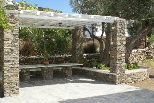 a stone bench under a white pergola at Villa Antoniadis in Platis Yialos Sifnos
