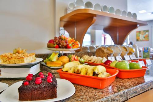 a buffet with a chocolate cake and fruit on a counter at Comfort Hotel Joinville in Joinville