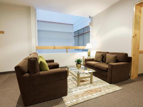 a living room with two chairs and a table at Qorianka Hotel in Lima