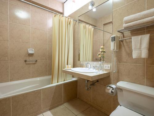 bagno con lavandino, vasca e servizi igienici di Qorianka Hotel a Lima