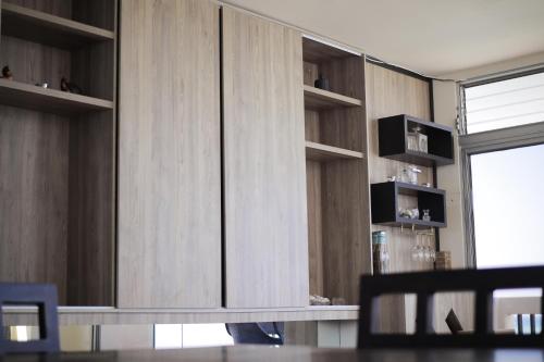 a living room with wooden cabinets and a table at Departamento Completo Frente Al Mar San Lorenzo Salinas in Salinas