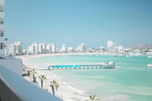 a view of a beach with a pier and buildings at Departamento Completo Frente Al Mar San Lorenzo Salinas in Salinas