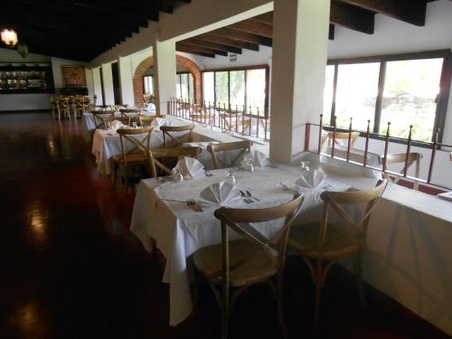 uma sala de jantar com mesas e cadeiras com roupa de mesa branca em Hotel Hacienda Taboada (Aguas Termales) em San Miguel de Allende