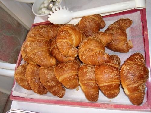een dienblad met croissants bovenop bij Hotel Villa Carla in Grado