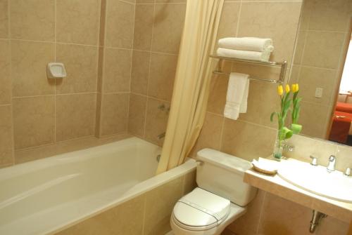 a bathroom with a tub and a toilet and a sink at Qorianka Hotel in Lima