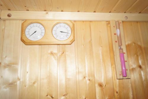 a wooden wall with two clocks on it at Вила Поликсения Петиня in Tryavna