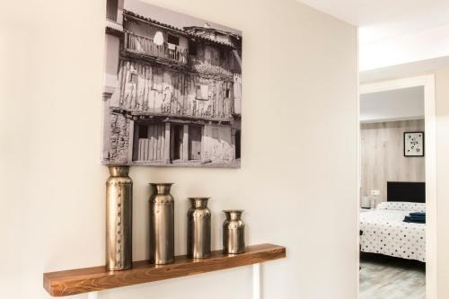 une étagère avec trois vases en argent sur un mur dans l'établissement Apartamento La Campanina, à La Alberca