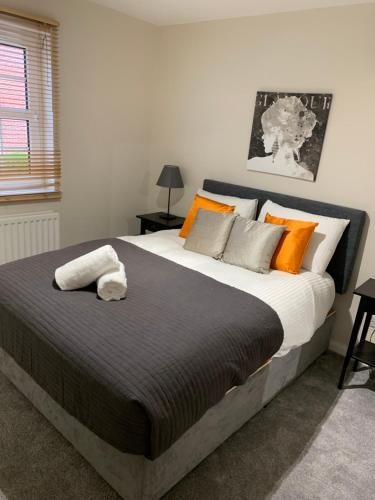 a bedroom with a large bed with orange and gray pillows at 4 bed Duplex Apartment, Belfast in Belfast