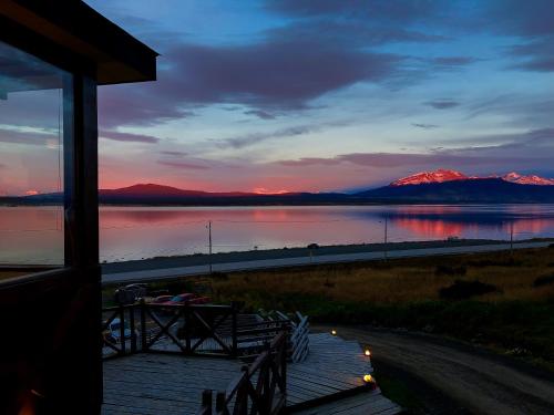 a view of a lake at sunset with mountains at Weskar Lodge Hotel in Puerto Natales